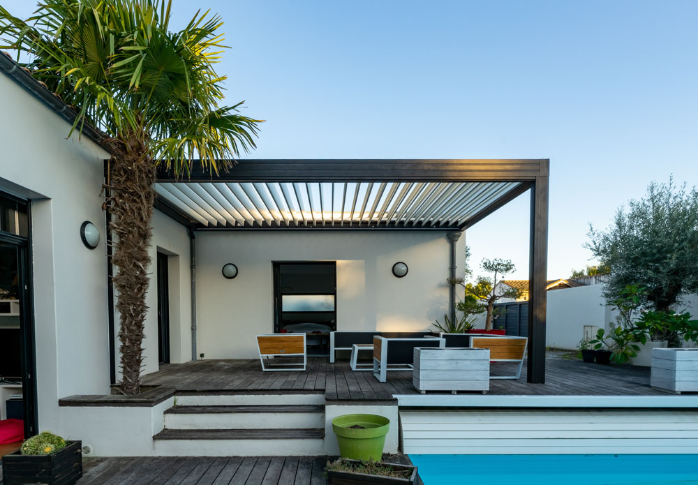 Pergola avec salon d'extérieur à coté d'une piscine